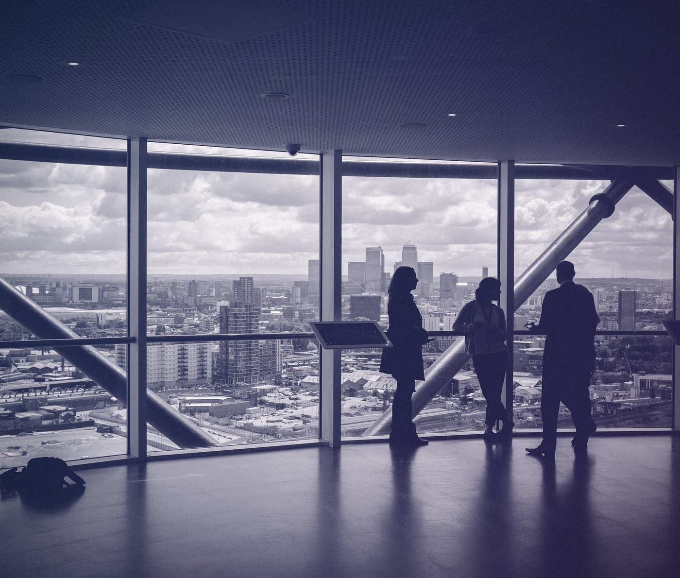Professionals in conversation overlooking a city skyline